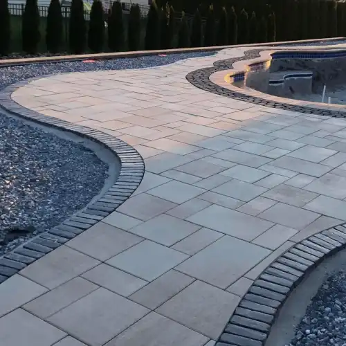 a brick patio installed around a pool